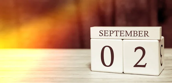 Kalender herinnering event concept. Houten blokjes met nummers en maand op 2 september met zonlicht. — Stockfoto