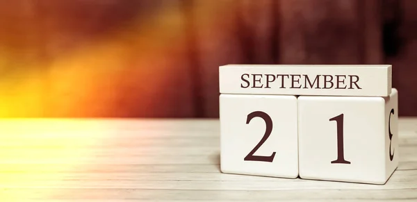 Konsep acara pengingat kalender. Kubus kayu dengan nomor dan bulan pada tanggal 21 September dengan sinar matahari . — Stok Foto