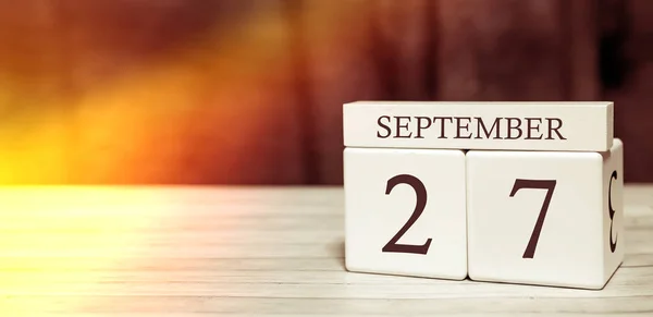 Kalender herinnering event concept. Houten blokjes met nummers en maand op 27 september met zonlicht. — Stockfoto