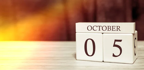 Calendario recordatorio concepto de evento. Cubos de madera con números y mes el 5 de octubre con luz solar . —  Fotos de Stock