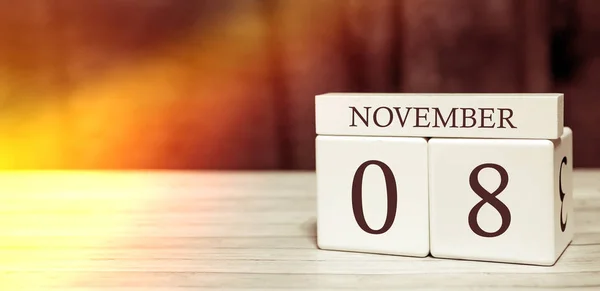 Koncepcja wydarzenia przypominającego kalendarz. Drewniane kostki z liczbami i miesiącem 8 listopada światłem słonecznym. — Zdjęcie stockowe
