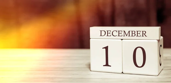 Концепція події нагадування календаря. Дерев'яні кубики з цифрами і місяцем 10 грудня з сонячним світлом . — стокове фото