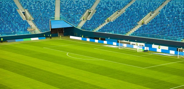 Football (soccer) stadium with a green lawn without spectators, end of the game