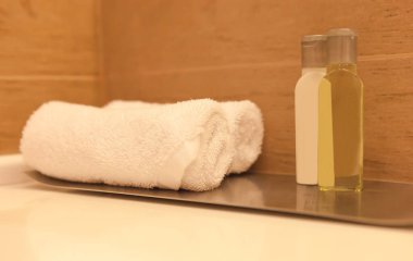 Beyaz havlu, bir otel spa tuvaletinin masasında, bulanık ahşap arka planda.