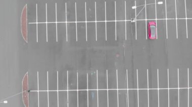 Boş bir otoparkta, havadan çekilmiş yalnız kırmızı bir araba. Coronavirus 'a karşı mücadele kavramı.