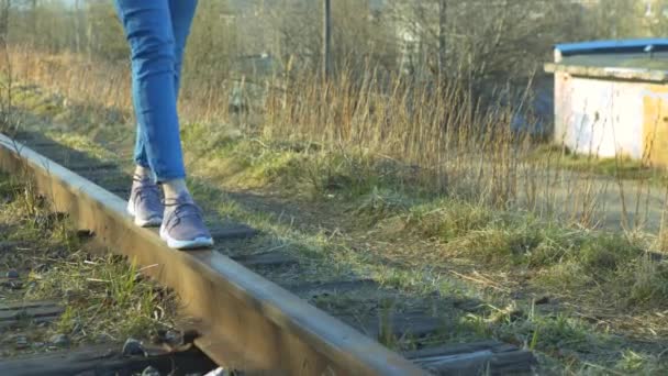 Ένα Κορίτσι Αθλητικά Παπούτσια Και Τζιν Περπατάει Ράγες — Αρχείο Βίντεο