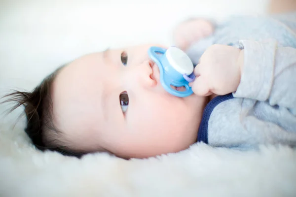 Cute Baby Jest Ssanie Smoczka Spanie Miękkich Biały Dywan — Zdjęcie stockowe