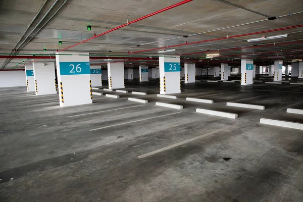 Öğleden sonra içi boş uzay parkı. Kapalı otopark. Otoparkın içinde, içinde araba ve boş otopark var. Daire ya da mağazada boş bir otopark..