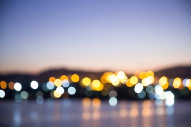 Bulanık bokeh alacakaranlık zamanında nehir şehrin ışık. güzel cityscape geceleri. görüntü arka plan, walllpaper ve kopya alanı için.
