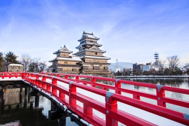 Japonya 'daki eski bir şato. Japonya 'nın Nagono şehrinde mavi gökyüzüne karşı Matsumoto kalesi. Yoğun kar yağışı olan Şato. Kış mevsiminde donmuş göletli Matsumoto Kalesi' ni gezin.