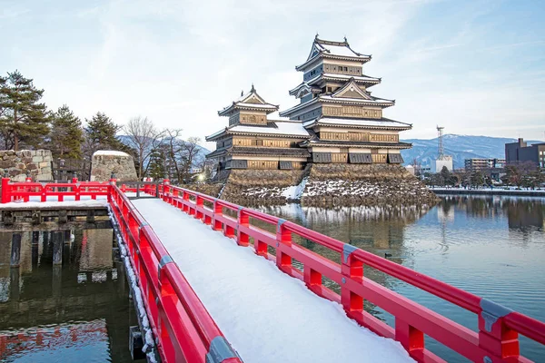 old castle in japan. Matsumoto castle against blue sky in Nagono city, Japan.Castle in Winter with heavy snowfall.Travel Matsumoto Castle with frozen pond in Winter.a Japanese premier historic castles