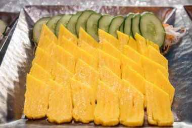 Tatlı tamago yumurtalı suşi - Japon yemek tarzı. Beyaz arka planda suşi omleti tamago.