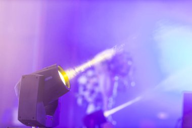 Sahne ışıkları, dumanlı parlak ışıklar, sahne aydınlatması. Sinema ışıkları, grunge duvarına karşı dumanlı. Konser ışıklandırma arkaplanı.