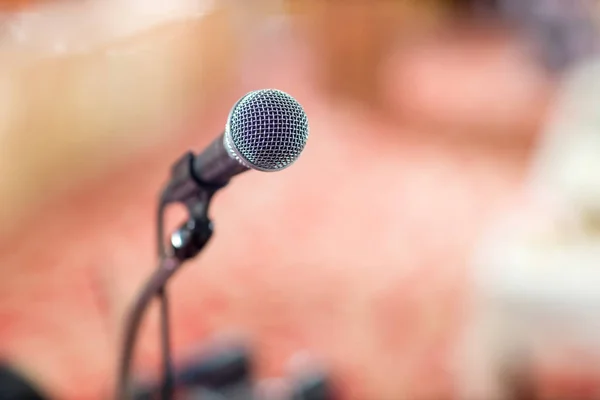Microphone in concert hall or conference room soft and blur style for background.Microphone over the Abstract blurred photo of conference hall or seminar room background.
