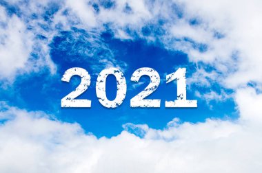 Gökyüzü bulutu yılı 2021. Mutlu yıllar konsepti. 2021 yılı mavi gökyüzüne karşı bulut. 2021 yılı. Parlak bir güneş tarafından aydınlatılan beyaz bulutların dumanından mavi gökyüzünün arkaplanındaki bir sembol.