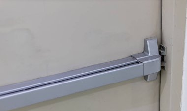 Acil çıkış kapısı. Kapalı kapı mandalı ve paslı acil çıkış kapısı. Panik çıkışı için parmaklıkları itin. Tek yönlü kapıyı aç. Beyaz kapı yangın çıkışı için çelik saplı.