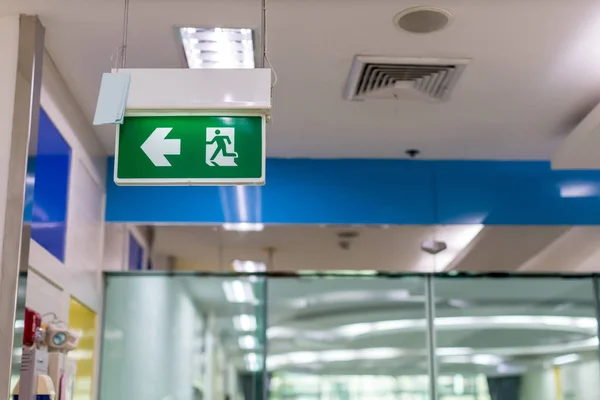 Green emergency exit sign showing the way to escape.Fire exit in the building.