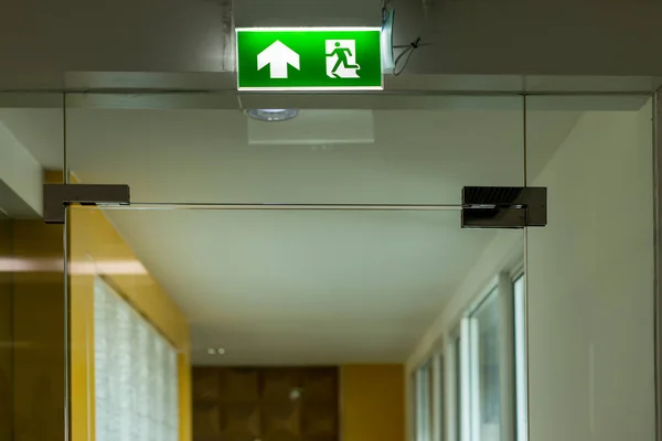 Green emergency exit sign showing the way to escape.Fire exit in the building.