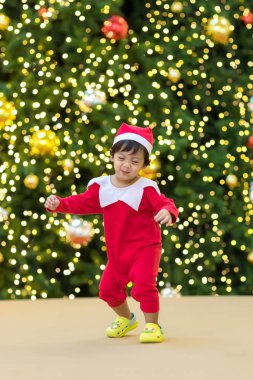 Dans hareketindeki sevimli Noel Baba. Noel eğlencesi. Santa Shirt 'lü bebek renkli ve mutlu görünüyor. Küçük çocuk Noel Baba şapkası takıp dans ederek ve eğlenerek Noel 'i kutluyor..