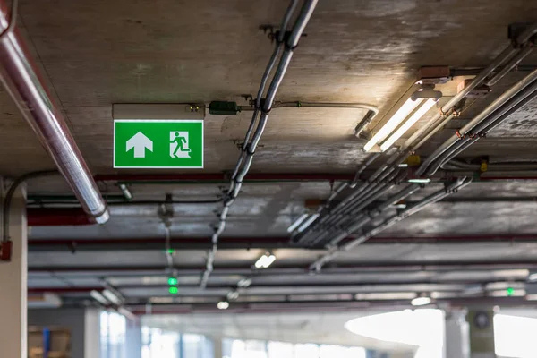 Green emergency exit sign showing the way to escape.Fire exit in the building.