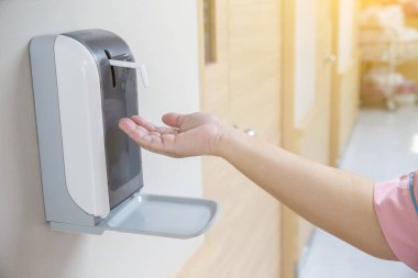 Hands under the automatic alcohol dispenser. Infection and hospitably concept. save and clean in the public area. 