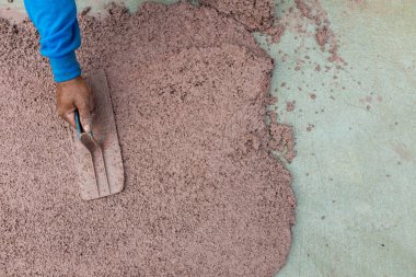 Worker plastering cement at wall or floor for building house. Construction worker plastering and smoothing concrete wall with cement. Plaster facade for wall decoration. Applying plastering mortar.