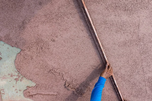 Worker plastering cement at wall or floor for building house. Construction worker plastering and smoothing concrete wall with cement. Plaster facade for wall decoration. Applying plastering mortar.