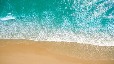 Metnin için fotokopi alanı olan turkuaz suyla çarpıcı güzellikteki deniz manzaralı bir kumsalın insansız hava aracı görüntüsü. Turkuaz suyla güzel bir kumsal, insansız hava aracı görüntüsü.