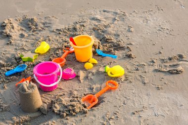 Plastik kum havuzu oyuncakları. Çocuklar tropikal kumsalda oyuncaklar. Plastik kürek ve deniz hayvanı şekilli oyuncaklar. Kumsaldaki çocuk aktiviteleri için favori oyuncaklar. Plaj oyuncaklarının tatil görüntüsü