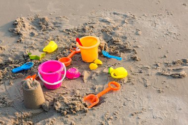Plastik kum havuzu oyuncakları. Çocuklar tropikal kumsalda oyuncaklar. Plastik kürek ve deniz hayvanı şekilli oyuncaklar. Kumsaldaki çocuk aktiviteleri için favori oyuncaklar. Plaj oyuncaklarının tatil görüntüsü