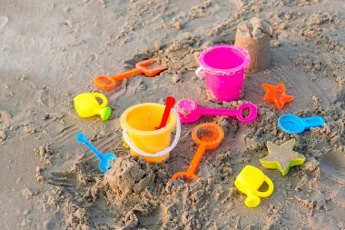 Plastik kum havuzu oyuncakları. Çocuklar tropikal kumsalda oyuncaklar. Plastik kürek ve deniz hayvanı şekilli oyuncaklar. Kumsaldaki çocuk aktiviteleri için favori oyuncaklar. Plaj oyuncaklarının tatil görüntüsü