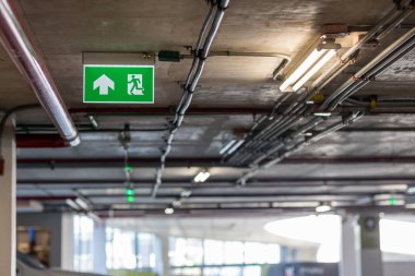 Kaçış yolunu gösteren yeşil acil çıkış işareti. Binadaki yangın çıkışı..