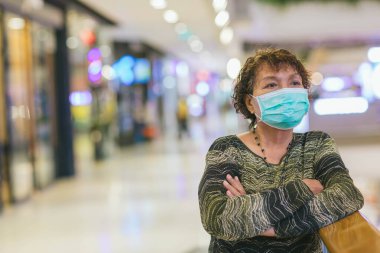 Kraliyet virüsüne karşı korunmak için Covid-19 maskeli yaşlı Asyalı kadın. Kirli hava dumanı yüzünden koruyucu maskeli Asyalı yaşlı kadın, PM2.5. Coronavirus yaşlı kadın ameliyat maskesiyle yürüyor.