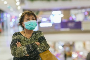 Kraliyet virüsüne karşı korunmak için Covid-19 maskeli yaşlı Asyalı kadın. Kirli hava dumanı yüzünden koruyucu maskeli Asyalı yaşlı kadın, PM2.5. Coronavirus yaşlı kadın ameliyat maskesiyle yürüyor.