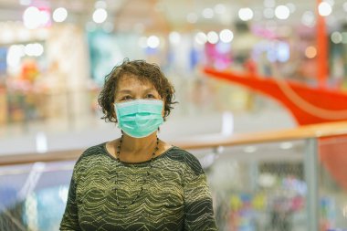 Kraliyet virüsüne karşı korunmak için Covid-19 maskeli yaşlı Asyalı kadın. Kirli hava dumanı yüzünden koruyucu maskeli Asyalı yaşlı kadın, PM2.5. Coronavirus yaşlı kadın ameliyat maskesiyle yürüyor.