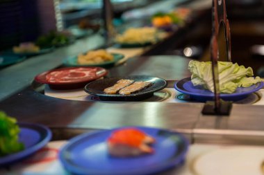 Japon restoranı yemek taşıyıcısı ya da açık büfe. Japon restoranındaki bulanık geçmişi olan kuşak suşisi..