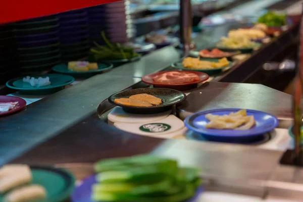 Japan restaurant food conveyor or belt buffet. belt sushi in japan restaurant with blurred background.