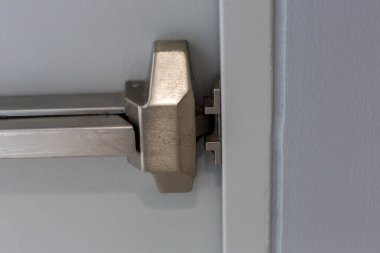 Acil çıkış kapısı. Kapalı kapı mandalı ve paslı acil çıkış kapısı. Panik çıkışı için parmaklıkları itin. Tek yönlü kapıyı aç. Beyaz kapı yangın çıkışı için çelik saplı.
