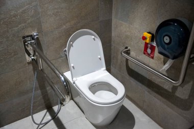 Büyük bir binada umumi tuvaletler. Engelliler için modern tuvalet. Tuvaleti ya da yaşlıları etkisiz hale getirin. Banyodaki engelliler ve yaşlılar için tırabzan..