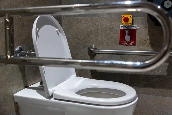 Public disabled toilet in a large building. Modern restroom for disabled people. Inside disable toilet or elderly people. Handrail for disabled and elderly people in the bathroom.