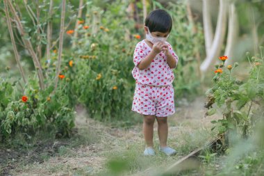 Child wearing a protective face mask on a city street with air pollution. Facial hygienic mask for Safety outdoor environmental awareness concept And protect disease virus against germs dustpm2.5