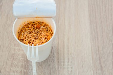 Sıcak erişte kupası. Erişte fincanı hazır. Plastik çatalla Anında Erişte yemek. Atıştırmalık erişteler popüler yemekleri yiyor..