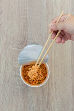 Sıcak erişte kupası. Erişte fincanı hazır. Plastik çatalla Anında Erişte yemek. Atıştırmalık erişteler popüler yemekleri yiyor..