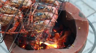 Tay nehri karidesleri mangal ızgarasında ızgara yapıp ızgara yapıyorlar. Büyük ızgara ıstakoz. Tay Caddesi 'ndeki yemek pazarında kömür ocağında pişiyor. Izgara Dev Karides..