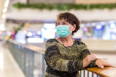 Kraliyet virüsüne karşı korunmak için Covid-19 maskeli yaşlı Asyalı kadın. Kirli hava dumanı yüzünden koruyucu maskeli Asyalı yaşlı kadın, PM2.5. Coronavirus yaşlı kadın ameliyat maskesiyle yürüyor.