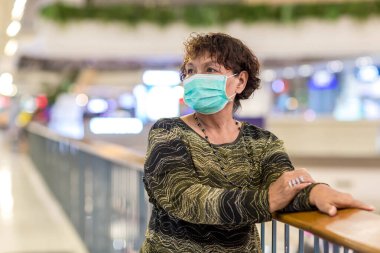 Kraliyet virüsüne karşı korunmak için Covid-19 maskeli yaşlı Asyalı kadın. Kirli hava dumanı yüzünden koruyucu maskeli Asyalı yaşlı kadın, PM2.5. Coronavirus yaşlı kadın ameliyat maskesiyle yürüyor.