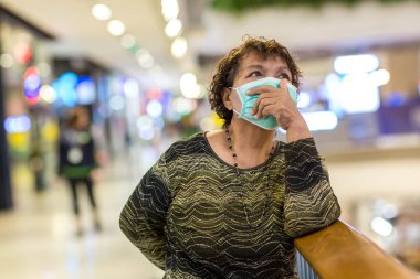 Kraliyet virüsüne karşı korunmak için Covid-19 maskeli yaşlı Asyalı kadın. Kirli hava dumanı yüzünden koruyucu maskeli Asyalı yaşlı kadın, PM2.5. Coronavirus yaşlı kadın ameliyat maskesiyle yürüyor.