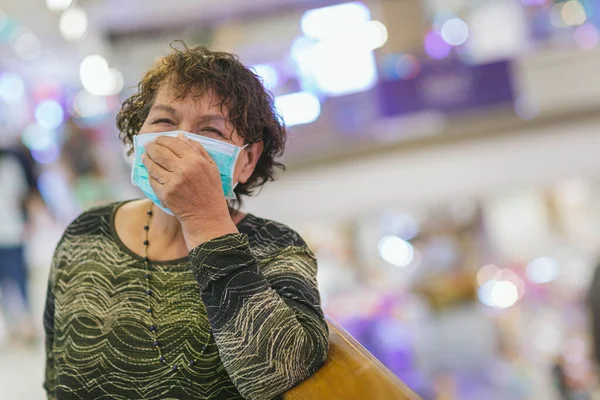 Old asian woman in a mask for COVID-19, for protection against the crown virus. Asian senior woman with protective mask because dirty air smog, PM2.5. Coronavirus old woman walking with surgical mask