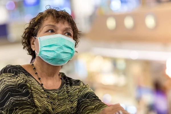 Old asian woman in a mask for COVID-19, for protection against the crown virus. Asian senior woman with protective mask because dirty air smog, PM2.5. Coronavirus old woman walking with surgical mask