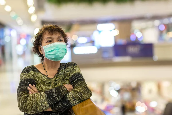 Kraliyet virüsüne karşı korunmak için Covid-19 maskeli yaşlı Asyalı kadın. Kirli hava dumanı yüzünden koruyucu maskeli Asyalı yaşlı kadın, PM2.5. Coronavirus yaşlı kadın ameliyat maskesiyle yürüyor.